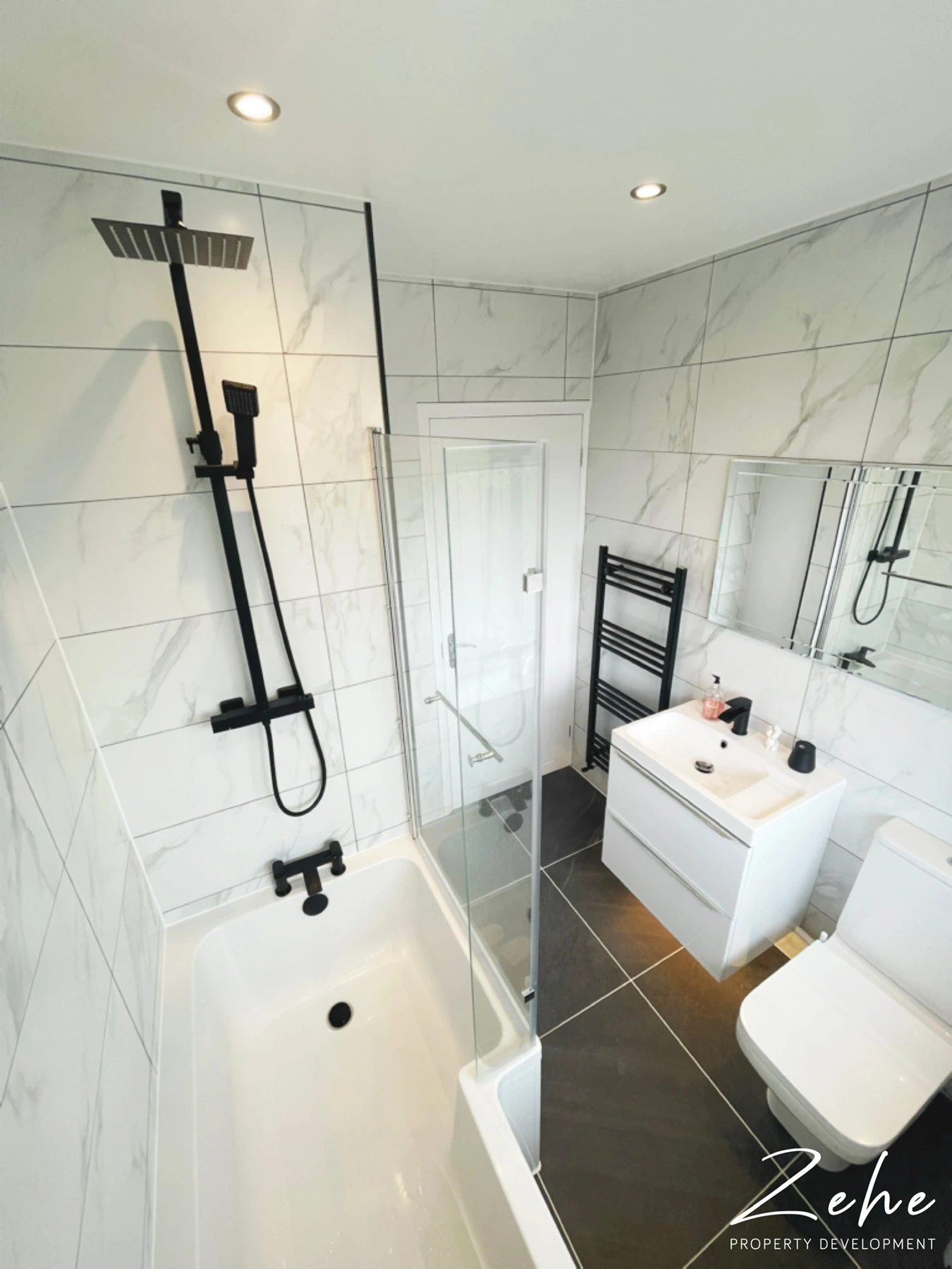Finished marble-effect bathroom with black fittings and a floating white vanity