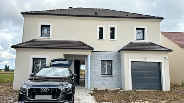 Exterior of a two-storey house during refurbishment, with the parked car registration concealed