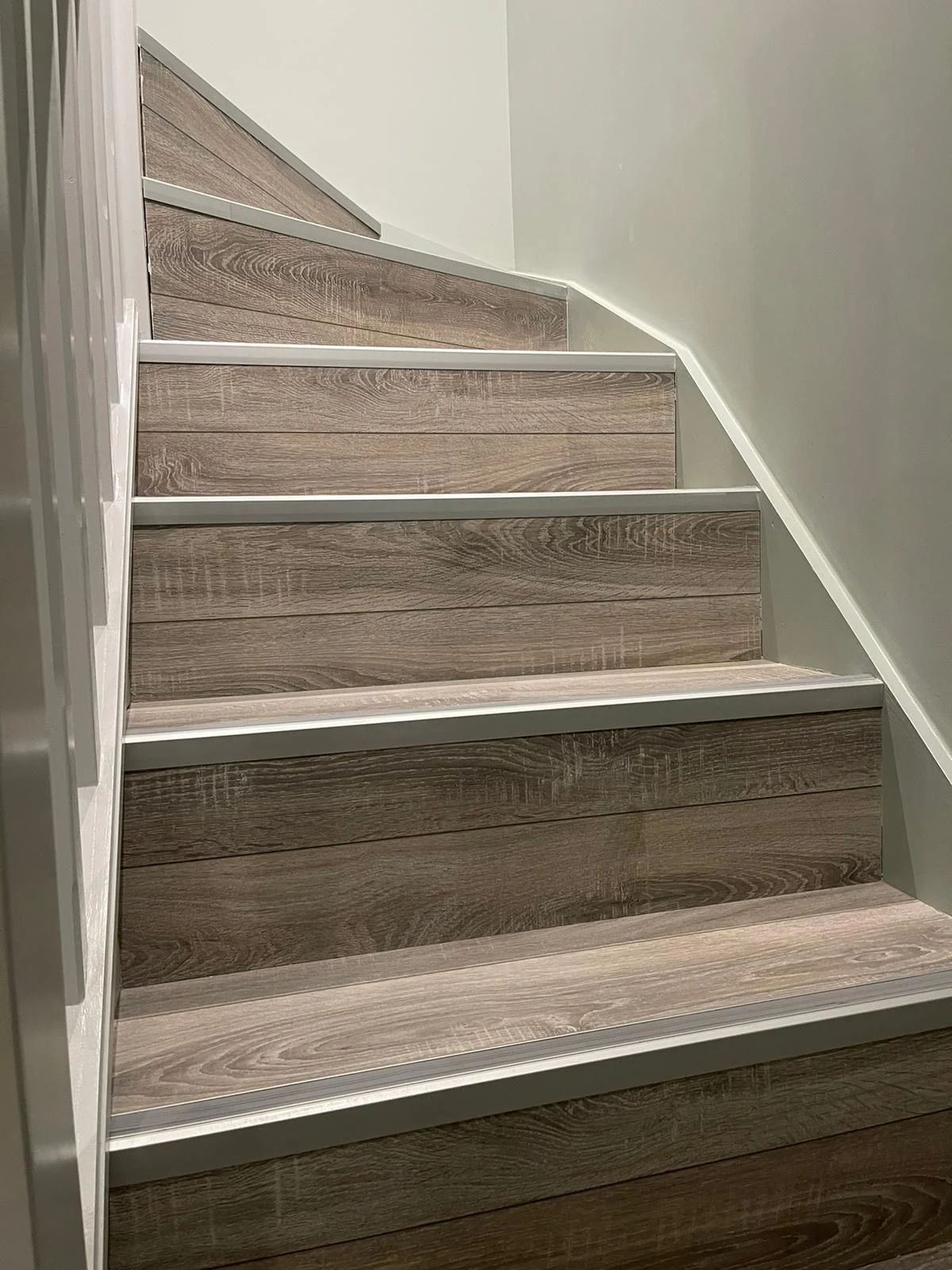 Refinished staircase with timber-effect treads and crisp white trim